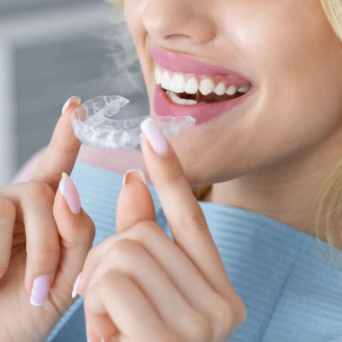 Lady putting in Invisalign